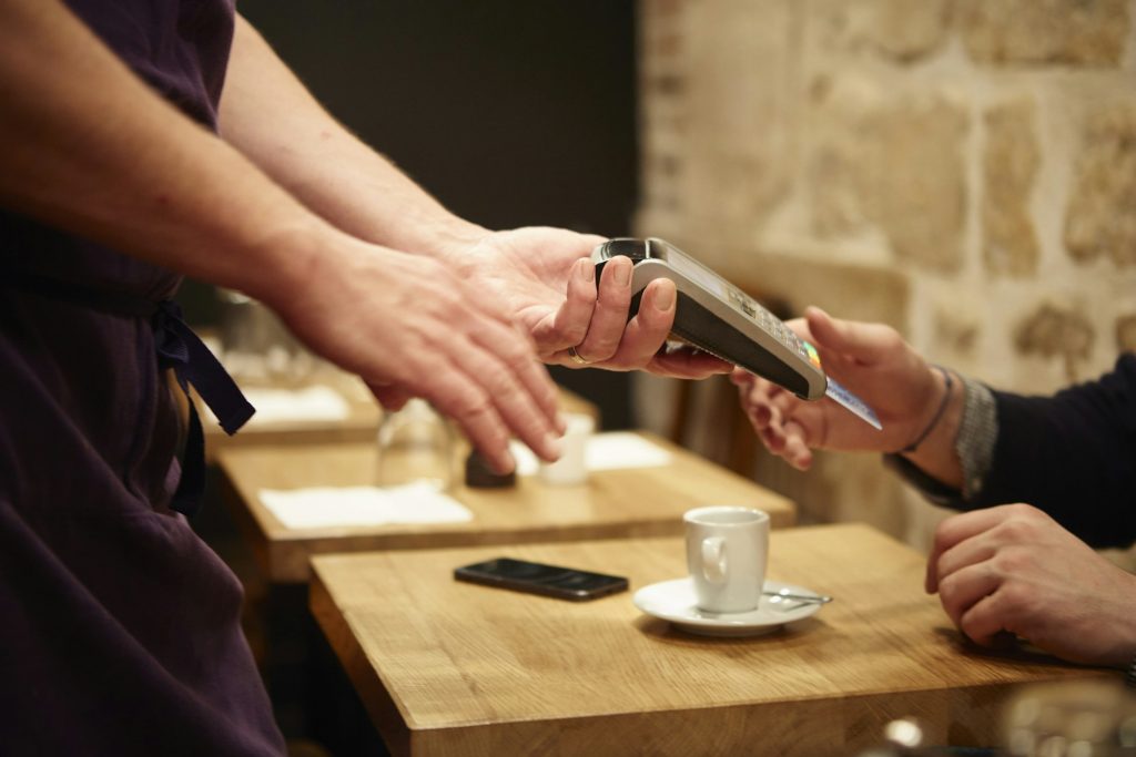 Man paying his bill in restaurant, using credit card